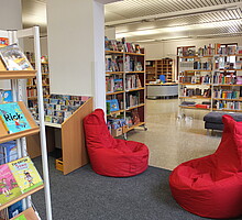 Kinderbuchbereich mit roten Sitzsäcken in der Gemeindebücherei Kirchentellinsfurt