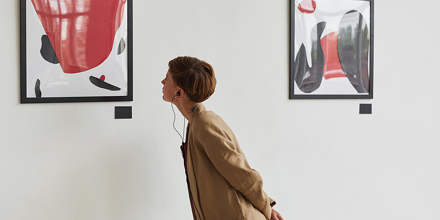Eine Frau betrachtet ein Bild in einer Ausstellung