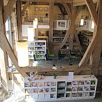 Blick von der Galerie in das Erdgeschoß mit Zeitschriftencafé und Veranstaltungsbereich in der Bibliothek Gomaringen (ehemalige Schlossscheuer)