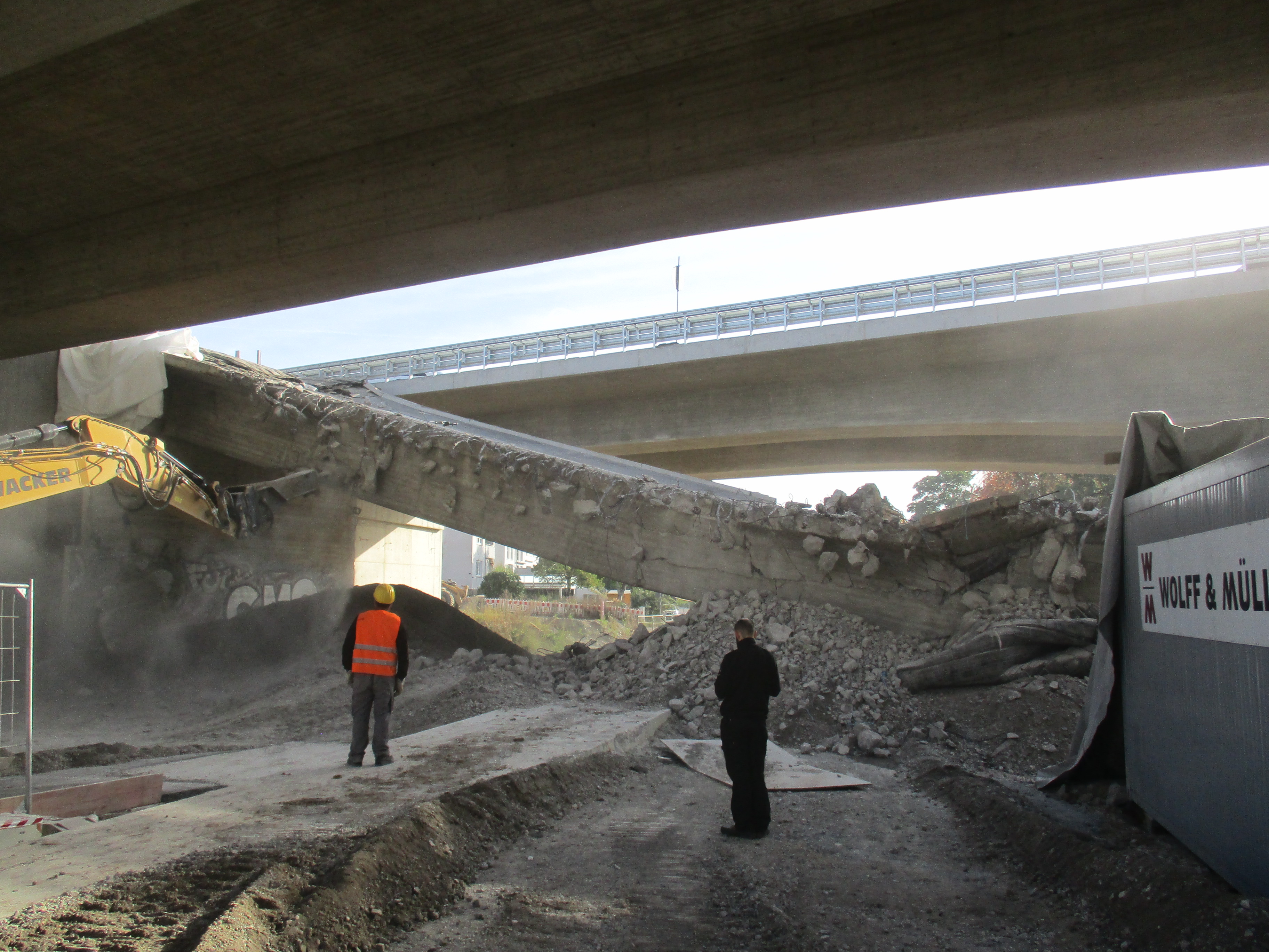 Bild zeigt zwei Bauarbeiter beim Abbruch der Brücke