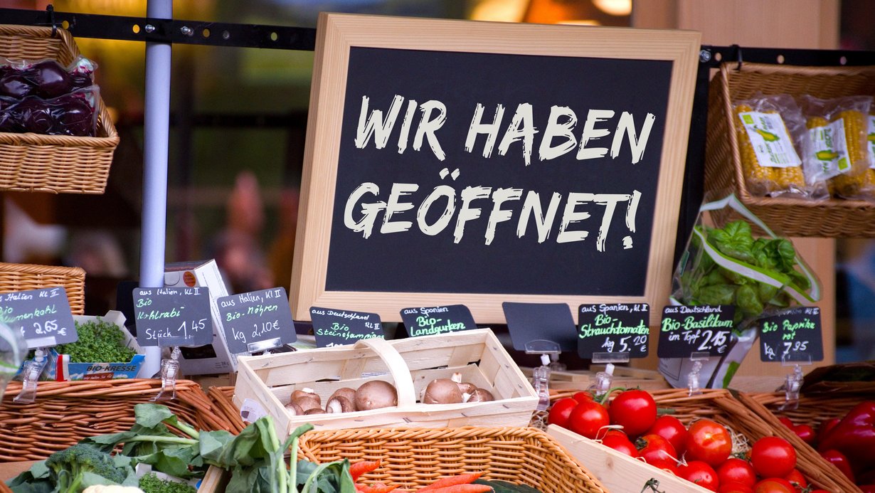 Schild auf Gemüsestand: Wir haben geöffnet
