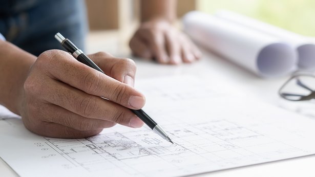 Ingenieur, der im Büro an Bauplan arbeitet