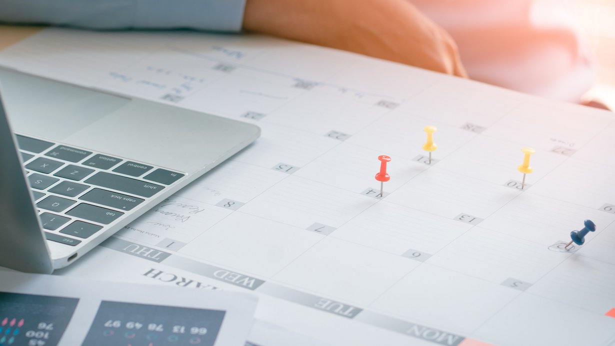 Das Bild zeigt eine Person mit einem Plan und Laptop