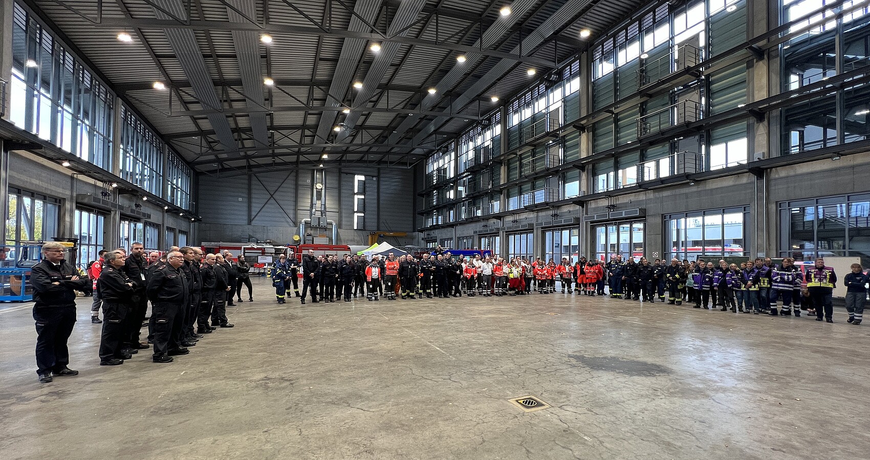 Das Foto zeigt alle Einsatzkräfte der Vollübung "Aufbau und Betrieb einer Notfallstation" der Landesfeuerwehrschule Bruchsal in einer großen Halle