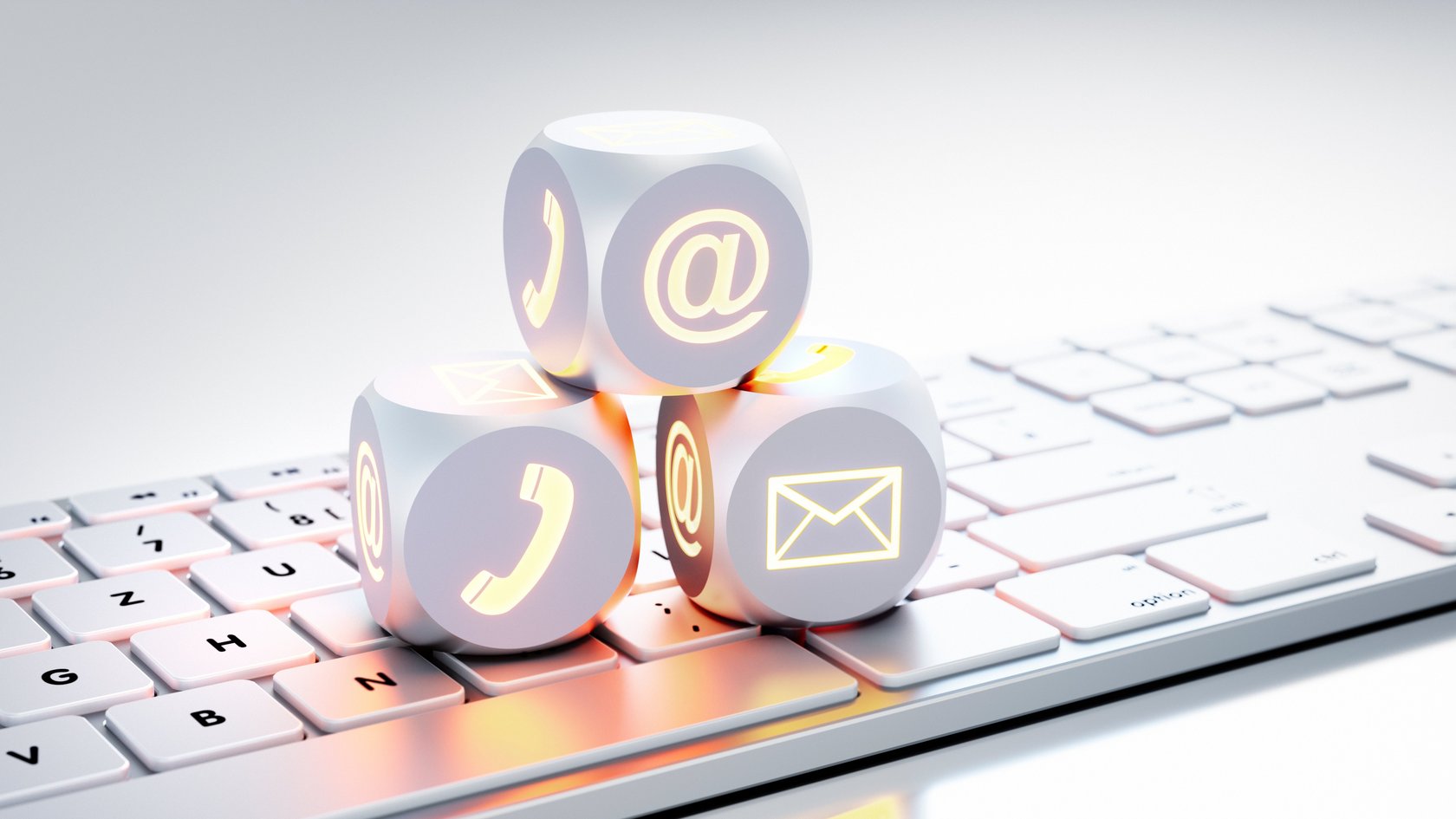 Auf einer Tastatur sind drei Würfel mit Kommunikationszeichen aufeinander aufgebaut