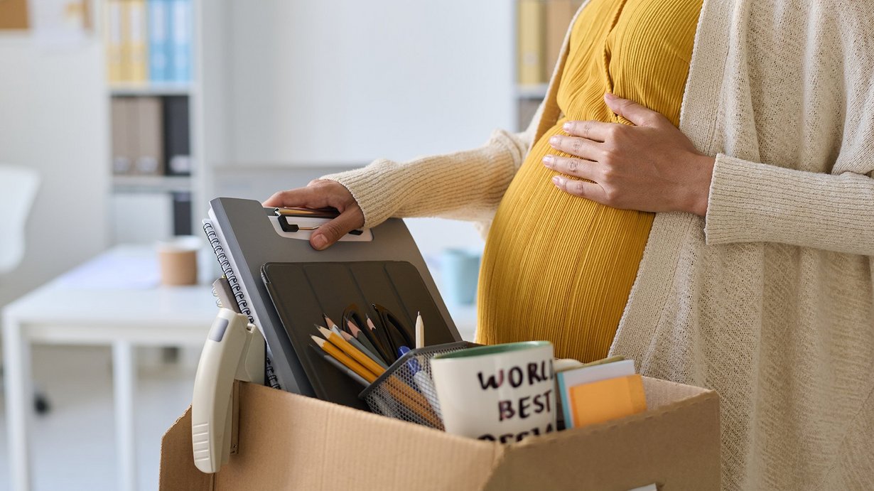 Schwangere packt ihre persönlichen Sachen und verlässt ihren Arbeitsplatz