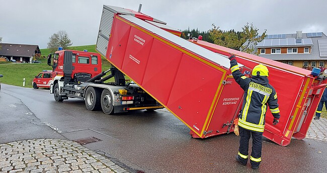 Ein Feuerwehrmann steht an einem umgekippten Lastwagen