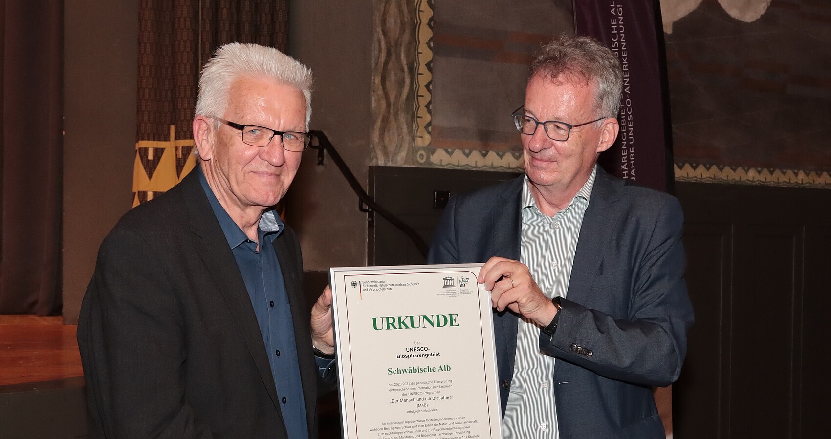 Das Bild zeigt Herrn Ministerpräsidenten Winfried Kretschmann und Dr. Stefan Lütkes bei der Urkundenübergabe zur Erneuerung der UNESCO-Auszeichnung des Biosphärengebiets Schwäbische Alb
