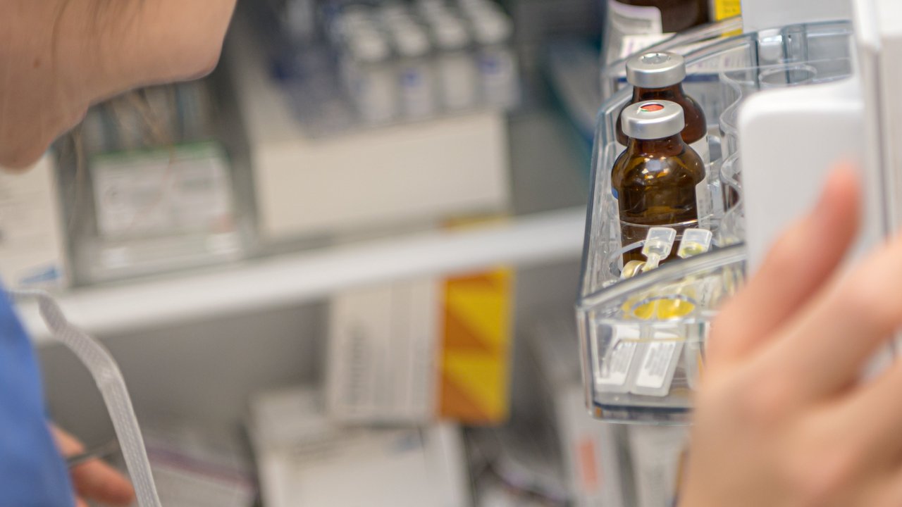 Eine Frau öffnet einen Kühlschrank, in dem Medikamente gelagert werden.