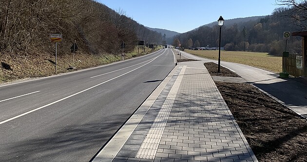 L 1208 zwischen Lustnau und Bebenhausen Das Bild zeigt die L 1208 zwischen Lustnau und Bebenhausen; rechts eine Bushaltestelle, ein Radweg und eine Straßenlaterne; links ein Hang mit Bäumen und Sträuchern und das Ortschild Ende Bebenhausen Richtung Tübingen