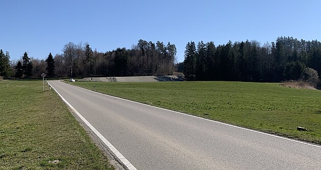 Blick auf die L 333 zwischen Pflegelberg und Primisweiler; links und rechts von der Straße sieht man Wiesen im Hintergrund Wälder und ein strahlend blauer Himmel