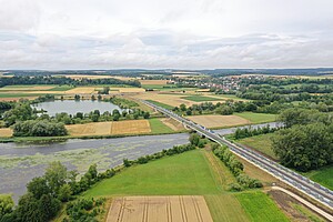 Luftbild von zwei Brücken über Gewässer. Auf den Irritationsschutzwänden stehen die Wörter "Donau" und "Kanal"