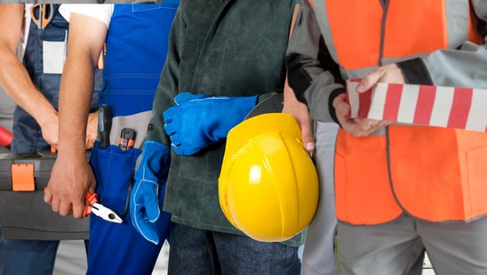 Arbeiter mit Sicherheitszubehör wie z.B. Schutzhelm und Absperrband 