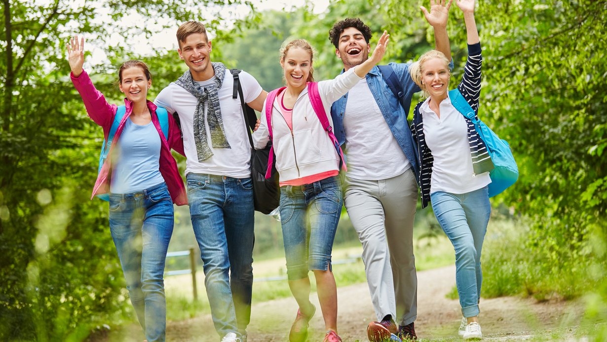 Mehrere fröhliche Jugendliche bei einer Wanderung