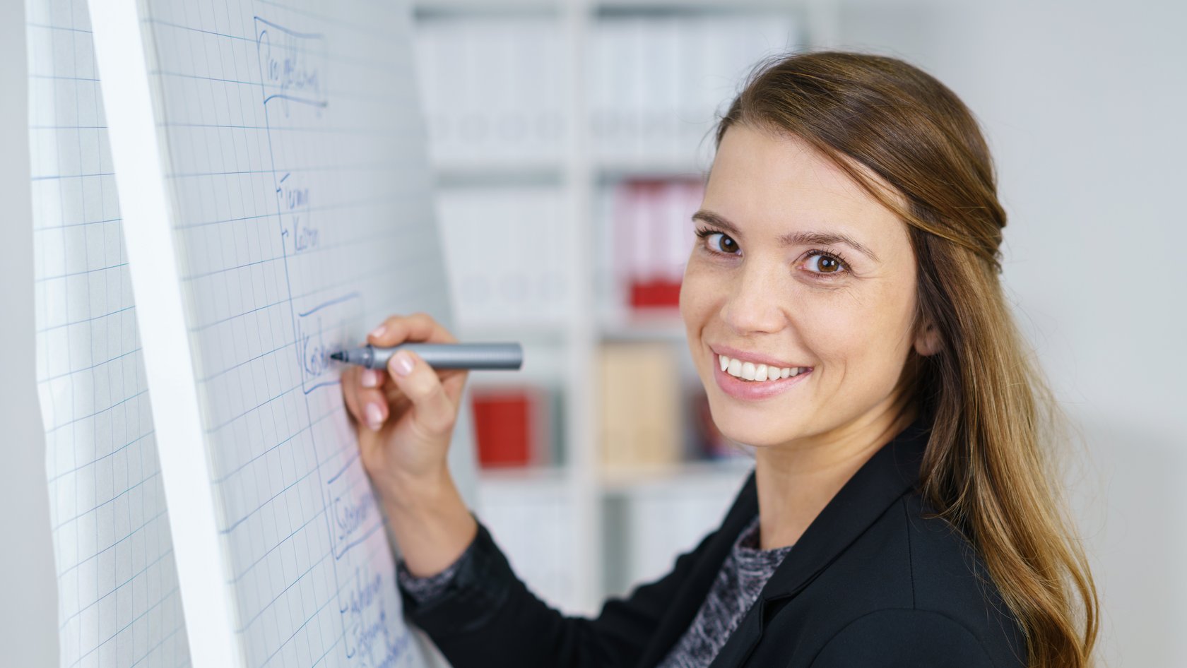 Frau steht am Flipchart
