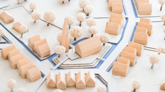 Modell-Holzhäuser auf einer weißen Fläche