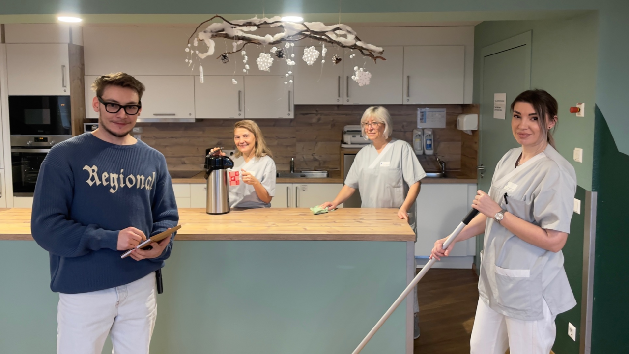  4 Mitarbeitende, drei Frauen und ein Mann, der Karlshöhe Ludwigsburg Altenhilfeblicken lächelnd in die Kamera