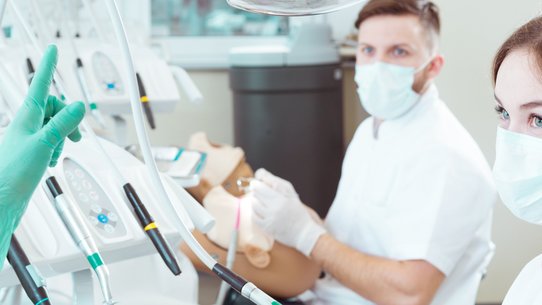 Zahnmedizinstudentin und Zahnmedizinstudent mit Ausbilderin