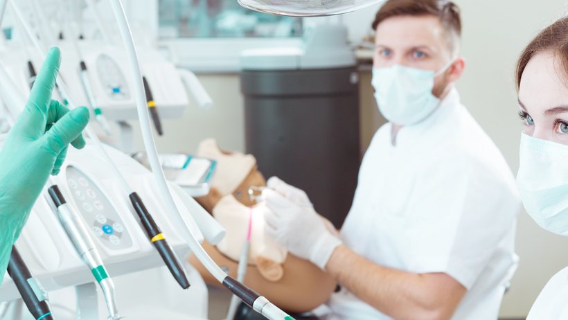 Zahnmedizinstudentin und Zahnmedizinstudent mit Ausbilderin