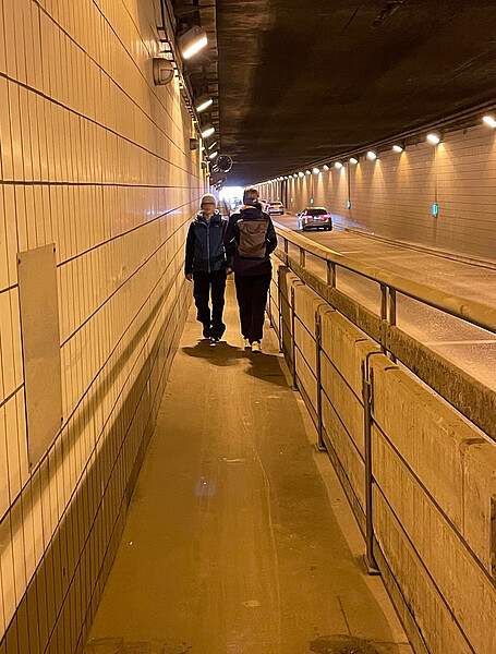 Bild zeigt den Flughafentunnel mit zwei sich entgegenkommenden Fußgängern