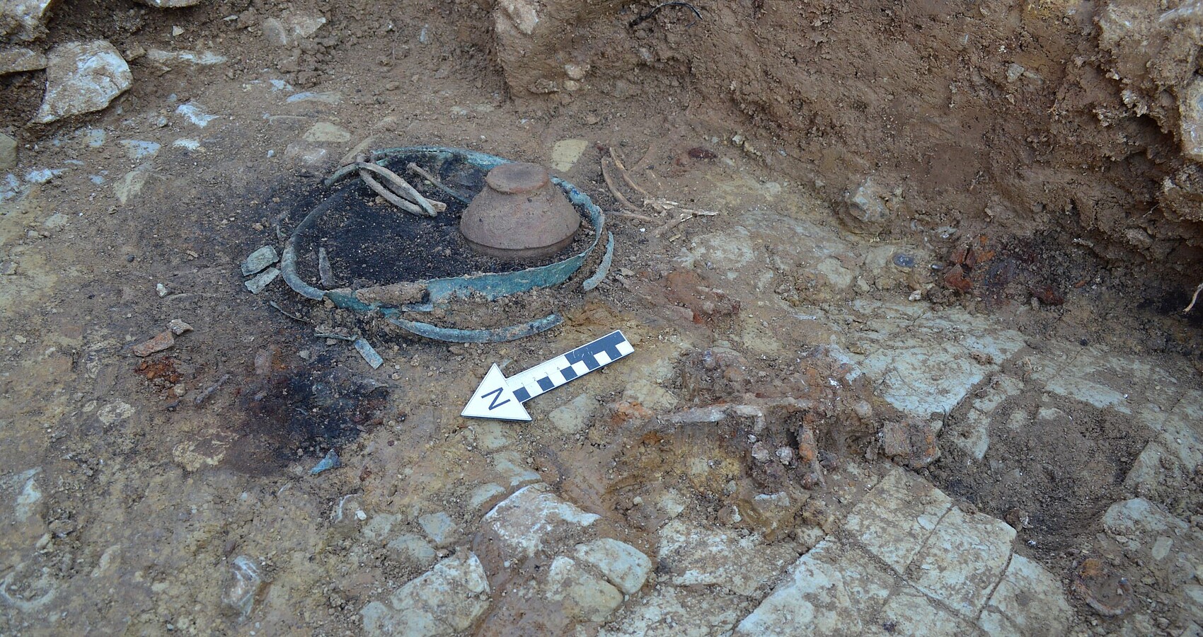 Bild zeigt die Reste des Gehänges mit Zierscheibe und Cypraea aus dem Frauengrab