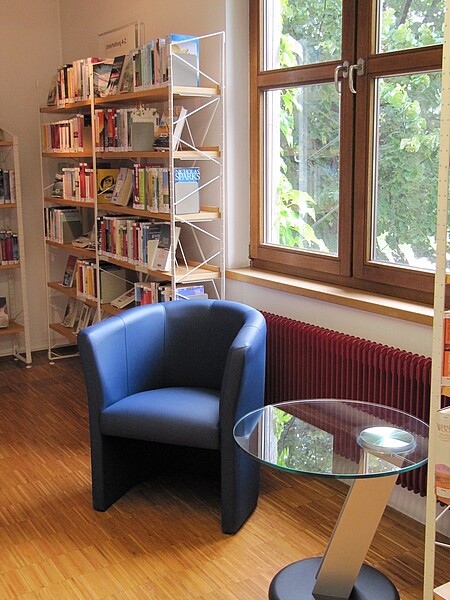 Leseplatz mit blauem Sessel und Glastisch in der Stadtbücherei Albstadt - Zweigstelle Tailfingen
