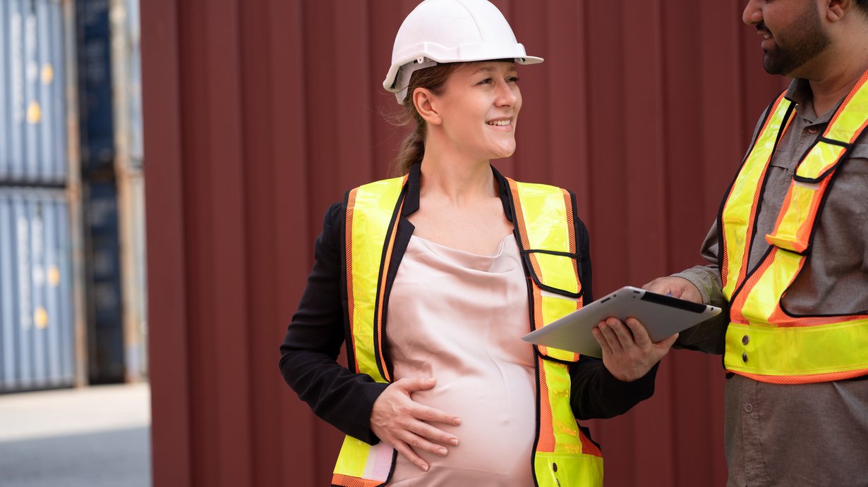 Schwangere Frau bei ihrer Tätigkeit auf einer Baustelle
