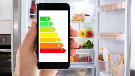 Eine Hand zeigt ein handy mit einem Energielabel