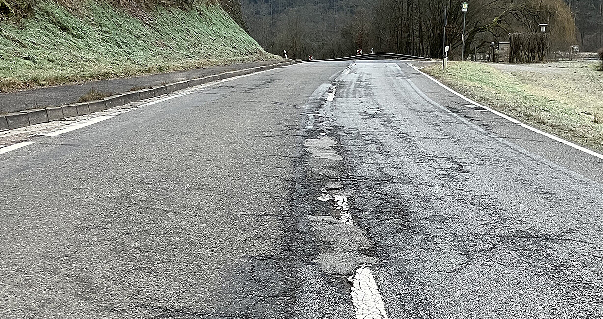 Straße mit Rissen und Verdrückungen