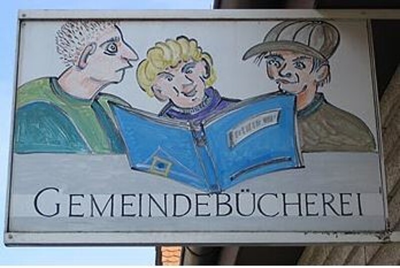 Gemeindebücherei Wilhelmsdorf - Aushängschild: Zeichnung mit 3 Jungs, die in ein Buch schauen