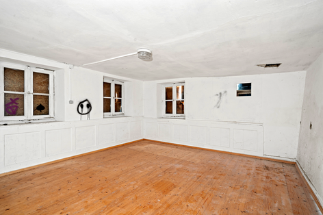 Bild zeigt ehemaligen Wohnraum mit weißen Wänden und Parkettboden im Erdgeschoss | 88521 Ertingen, Freihof 4 | Verkäufliches Kulturdenkmal im Landkreis Biberach