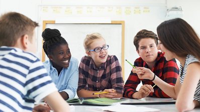 Schülerinnen und Schüler arbeiten gemeinsam an einem Projekt im Klassenraum