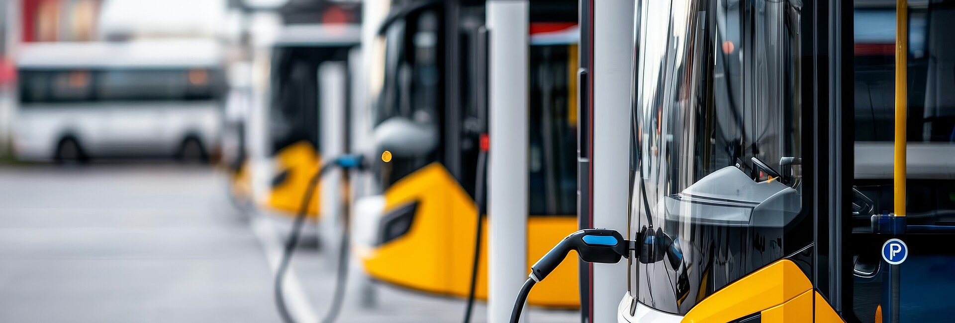 Ladestation für Elektrobusse, an der die Busse aufgereiht sind und über Oberleitungen aufgeladen werden