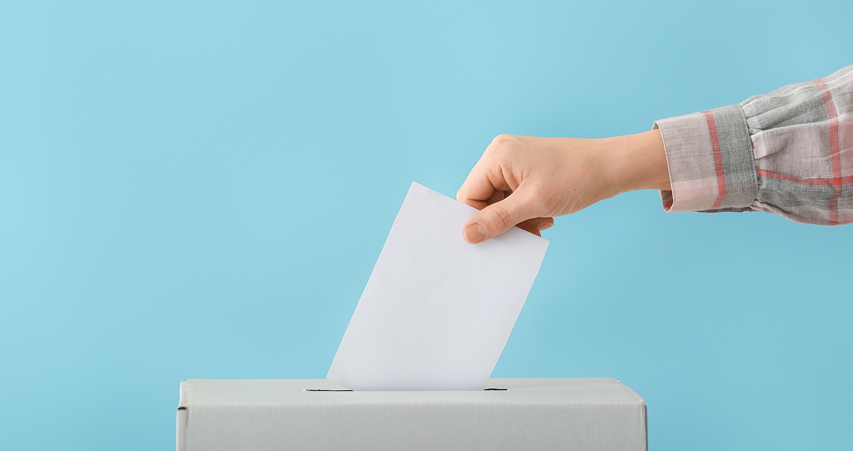 Eine Frau wirft einen Stimmzettel in eine Wahlurne