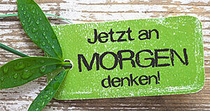 Grüne Plakette mit der Beschriftung "Jetzt an Morgen denken"