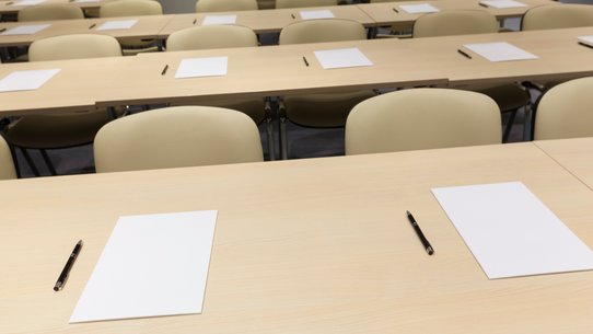 Bild zeigt einen leeren, für ein Examen vorbereiteter Kursraum