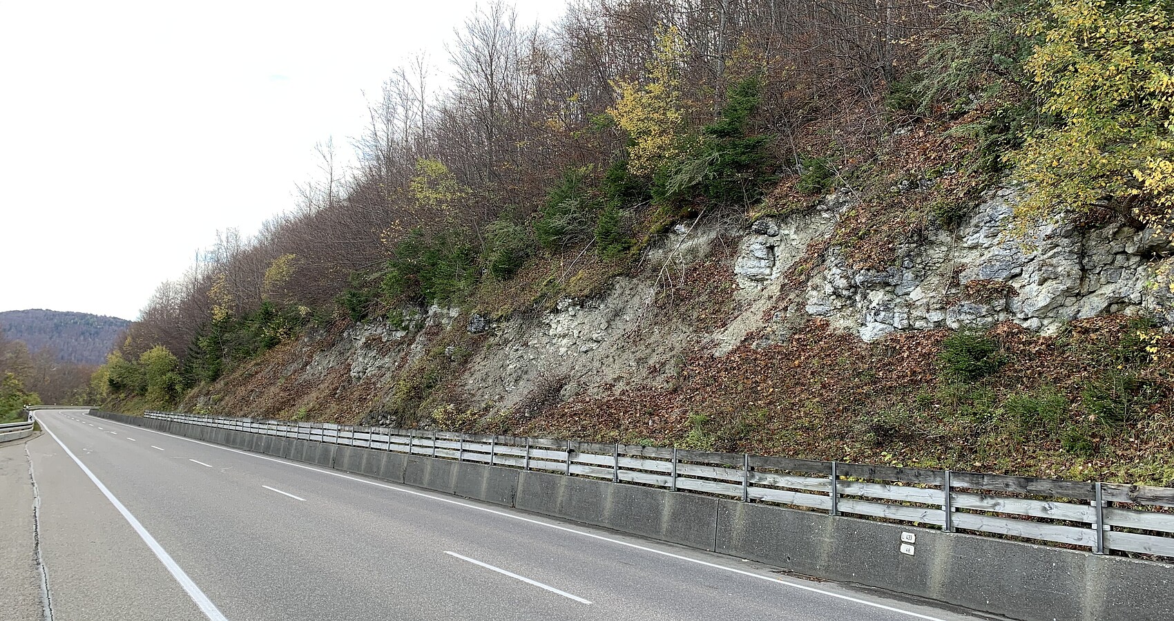 Das Bild zeigt die Meßstetter Steige; rechts eine Felsböschung und unterhalb ein Holzzaun und links eine Parkbucht