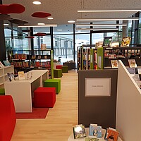 Bibliotheksraum der Mediathek am Teuringer, Oberteuringen, mit weißen Regalen, bunten Sitzmöbeln