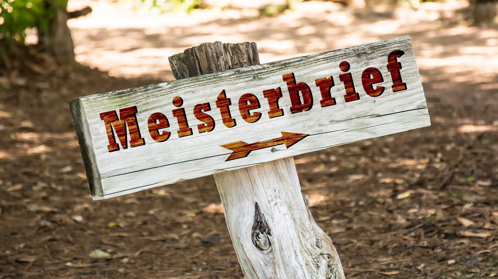 Holzschild mit brauner Beschriftung "Meisterbrief"; darunter zeigt ein Pfeil nach rechts