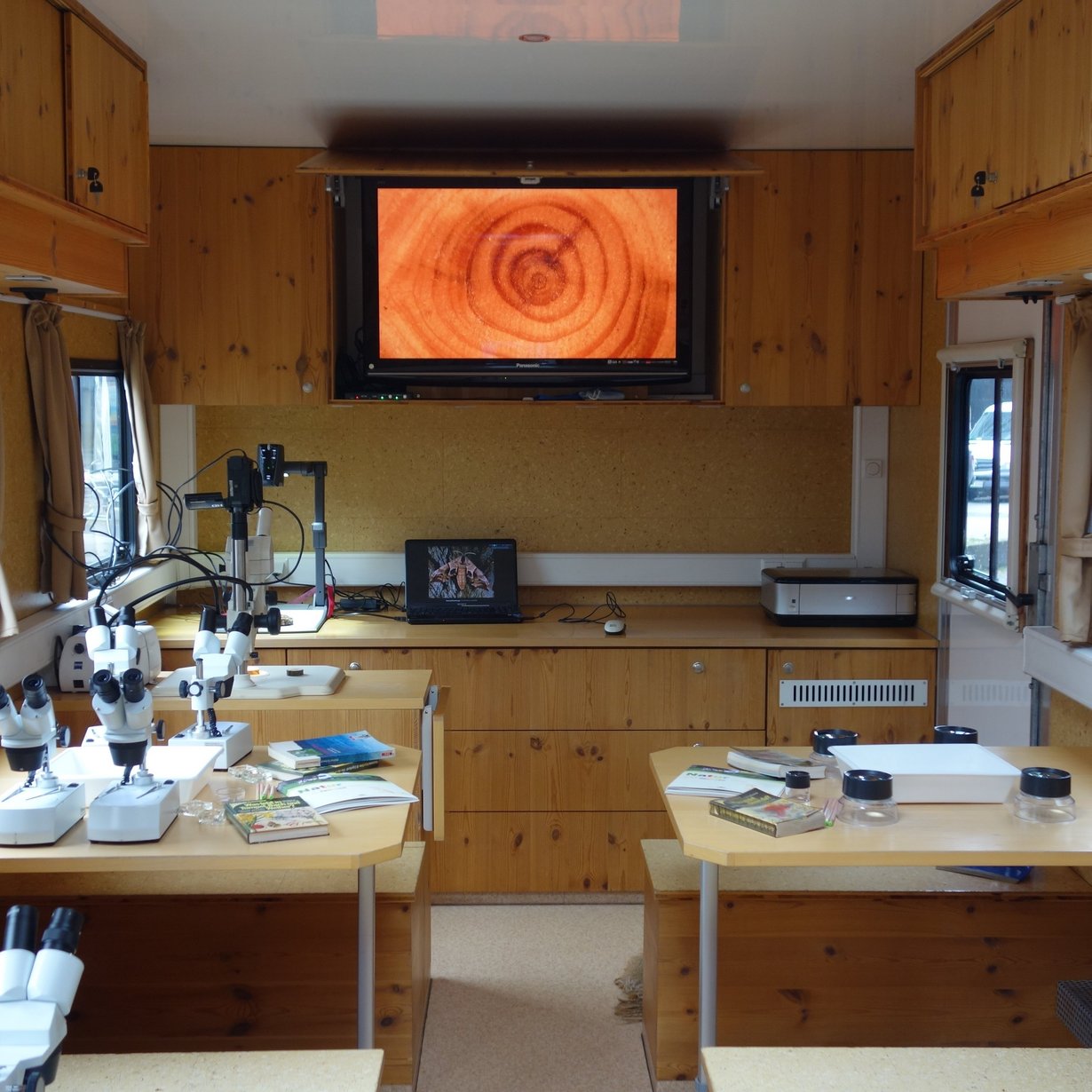 Innenansicht des Ökomobils mit Nahaufnahme einer Holzscheibe auf dem Monitor