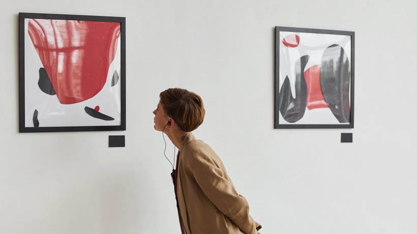 Eine Frau betrachtet ein Bild in einer Ausstellung