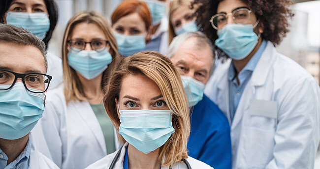 Symbolbild Medizinisches Personal - Menschengruppe mit Schutzmasken