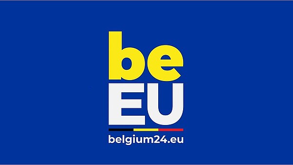 Das Bild zeigt das Logo der belgischen Ratspräsidentschaft: auf dunkelblauem Hintergrund steht in gelben Buchstaben „be“ und darunter in Weiß „EU“. Darunter befindet sich die die belgische schwarz-gelb-rote Fahne sowie ein weißer Schriftzug belgium24.eu. 