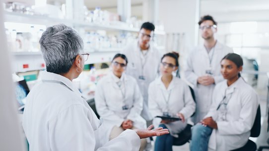 Bild zeigt ein Labor, wo eine Gruppe Pharmaziestudierender eine Unterweisung erhält