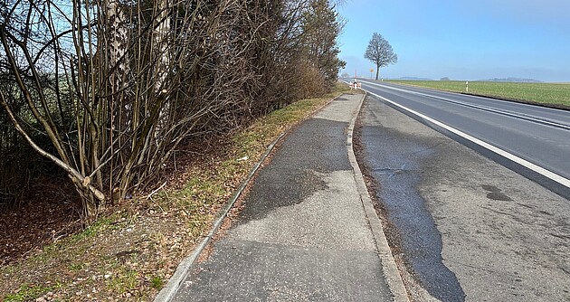 Das Foto zeigt die alte Bushaltebucht an der B 30 bei Enzisreute; links ein Waldstück