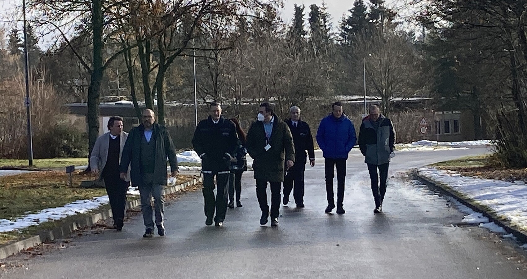 Regierungspräsident Tappeser im Gespräch mit Verantwortlichen in der LEA Sigmaringen - sie laufen einen Weg auf dem Gelände der LEA entlang.