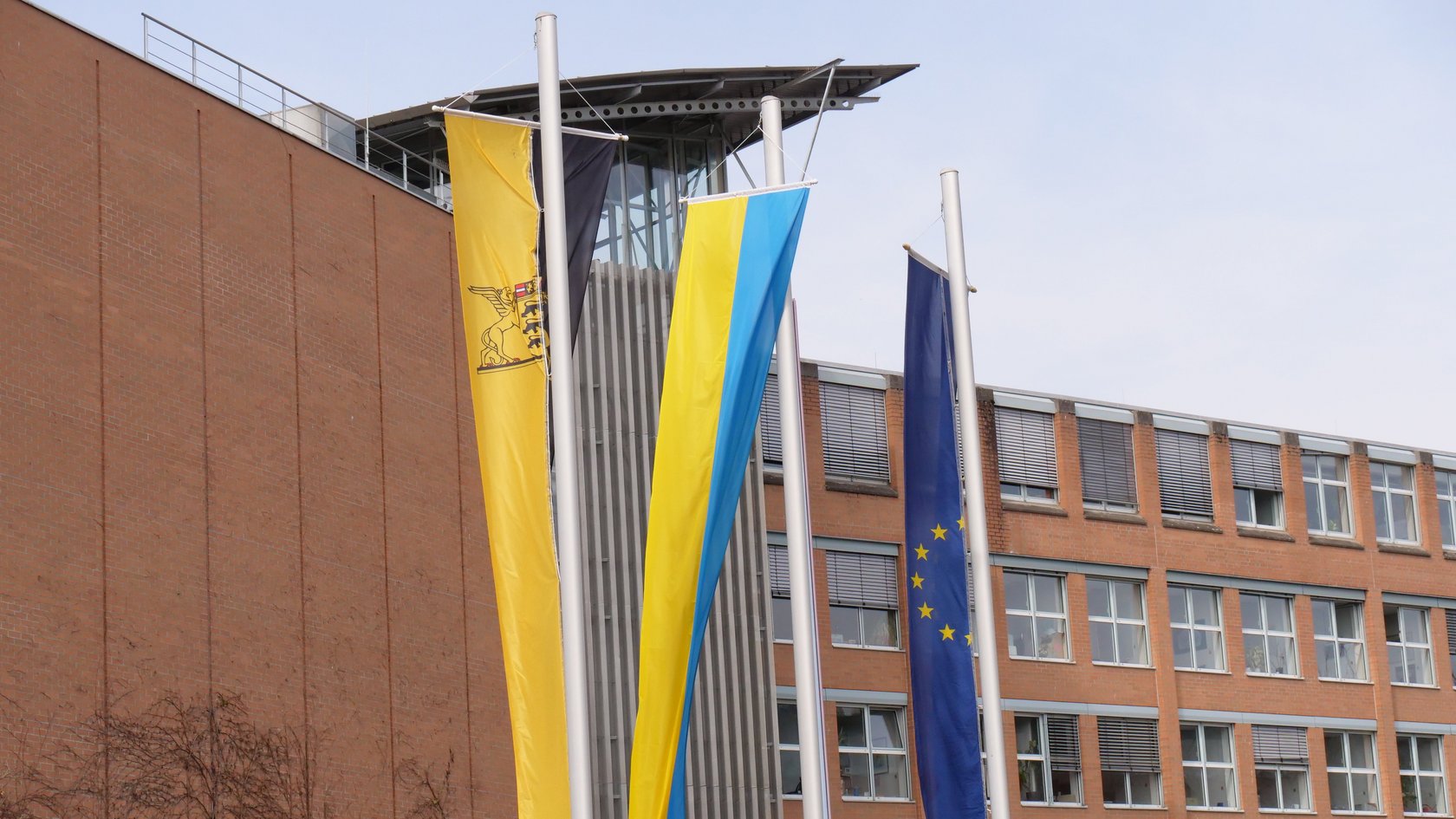 Die Fahnen von Europa, der Ukraine und Baden-Württemberg vor dem Hauptgebäude des Regierungspräsidiums Tübingen