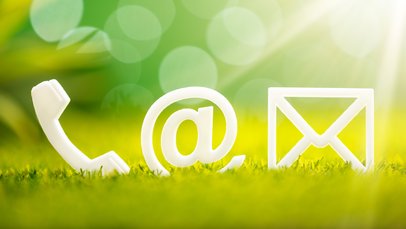 Weiße Kontakticons (Telefon, E-Mail, Briefumschlatg) auf Gras