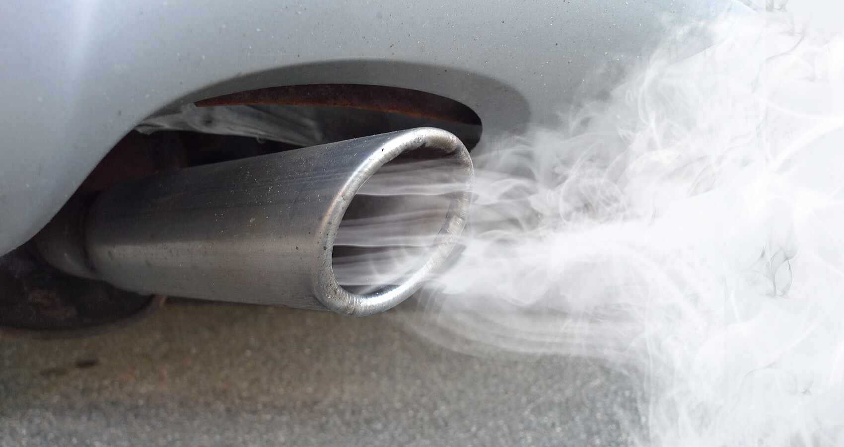 Bild zeigt einen rauchenden Autoauspuff