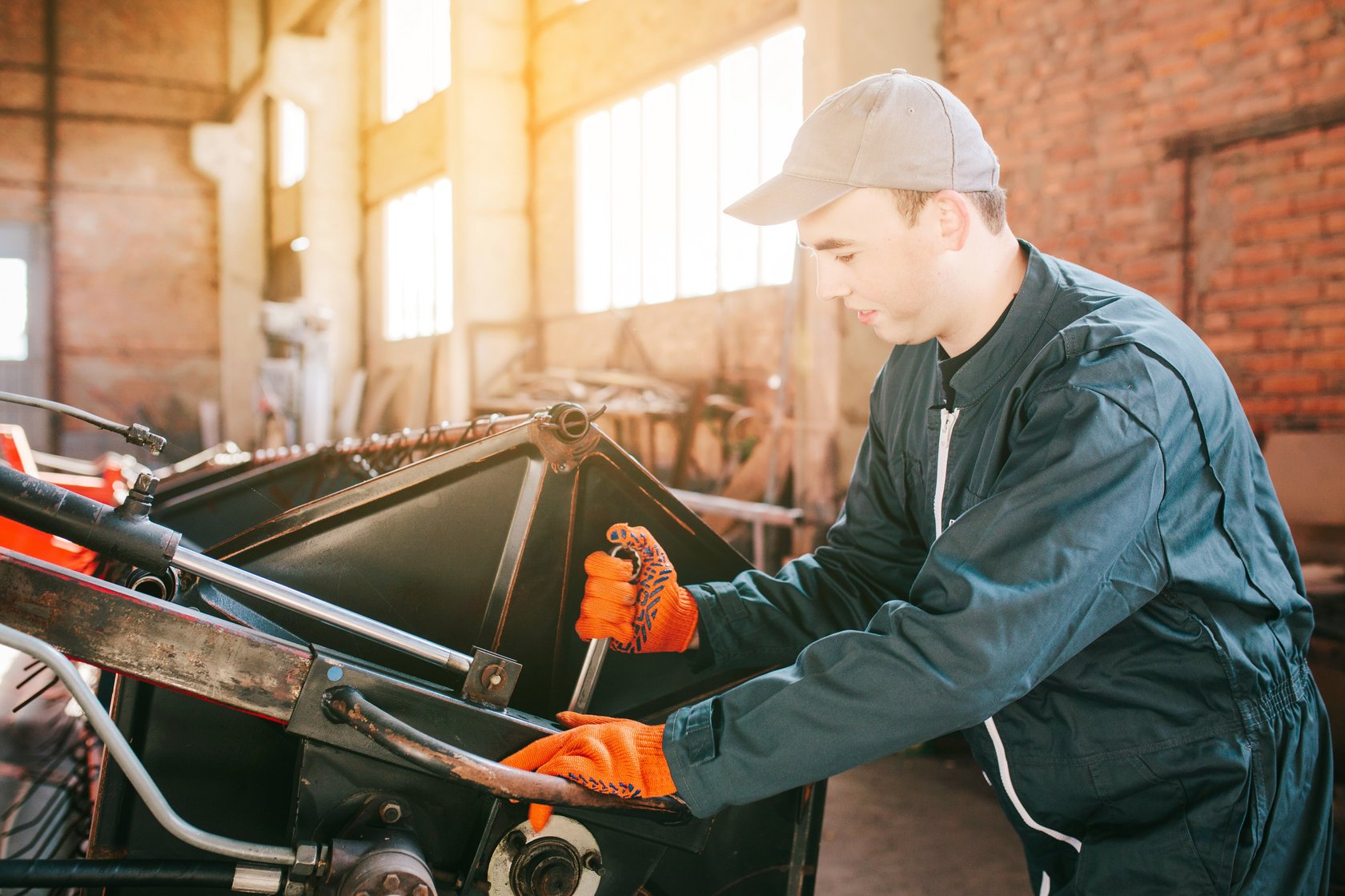 Auszubildender beim Warten einer landwirtschaftlichen Maschine